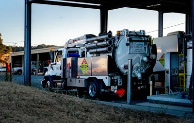 Fuel transport truck parked at an industrial site during daytime.